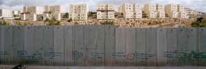 Mur de Shuafat avec des graffitis en premier plan et ville en arrière-plan