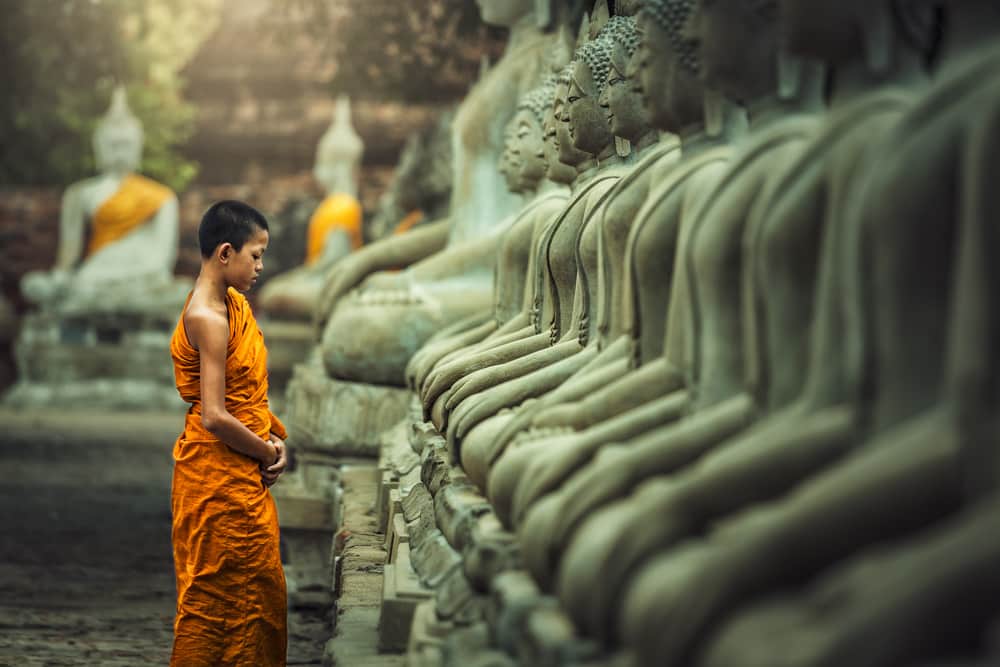 Méditation du moine novice vipassana devant la statue de Bouddha