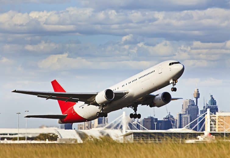 Un avion de ligne moderne décollant de l'aérodrome de l'aéroport contre les immeubles CBD de Sydney et les tours vers le ciel bleu.