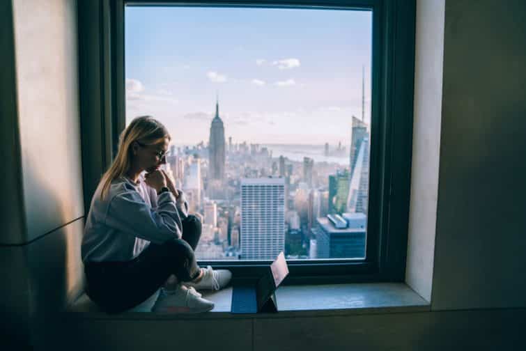 Jeune femme en train de travailler avec vue sur New York