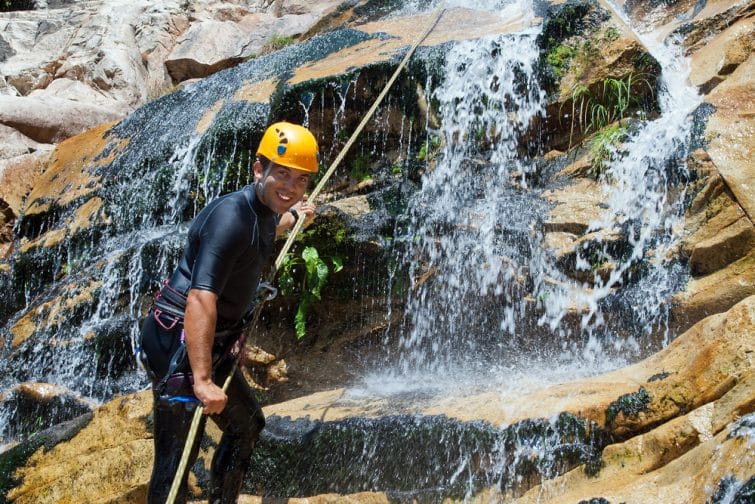 Men descending in rappeling a waterfall