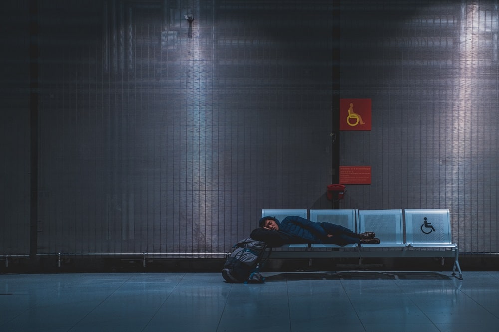 Voyageur dormant sur un banc à l'aéroport