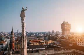 L'une des nombreuses statues de la cathédrale principale de Milan donne sur la ville