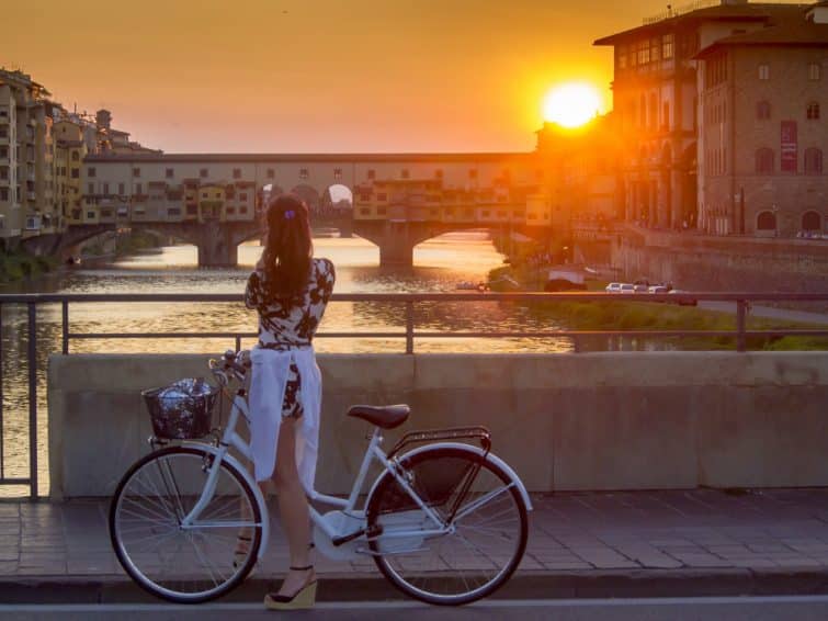 Touriste à vélo prenant en photo le coucher de soleil à Florence