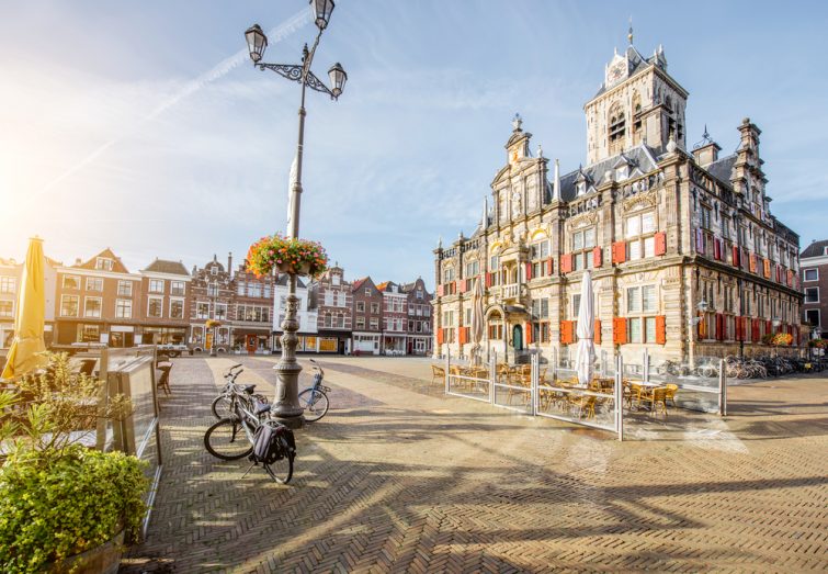 Vue sur l'hôtel de ville et de beaux bâtiments sur la place centrale pendant la matinée ensoleillée dans la ville de Delft, Pays-Bas