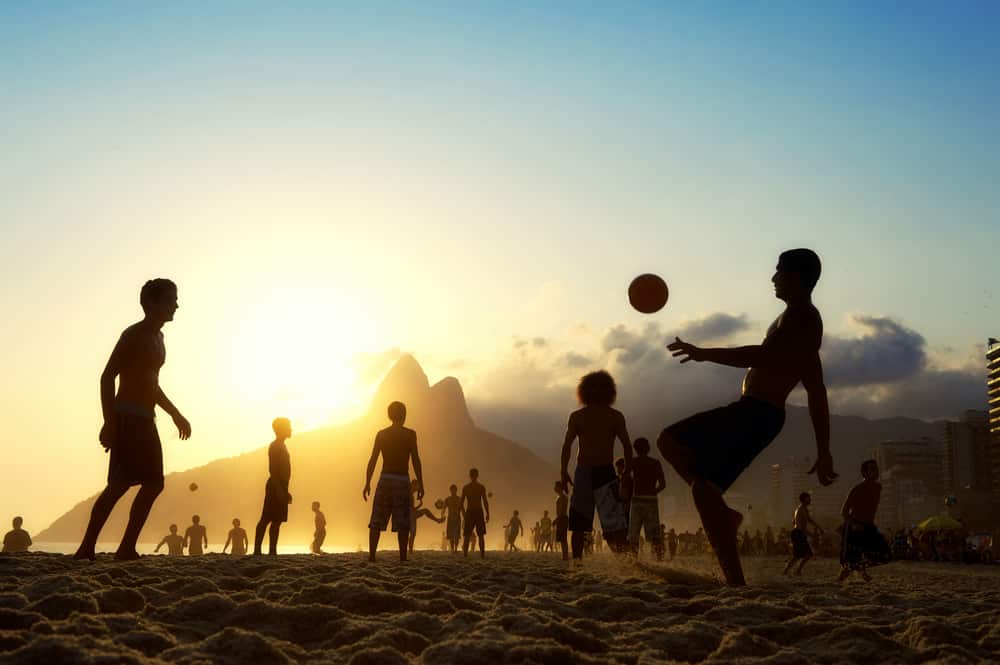 photos brésil - Silhouettes jouant au football sur la plage à Rio 