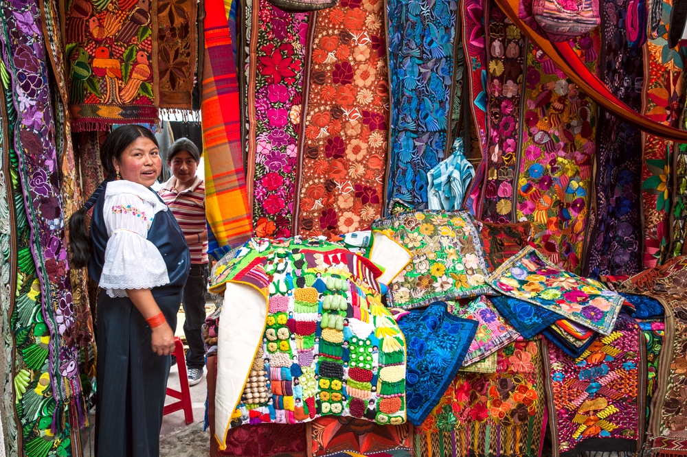 Équatorienne vendant des vêtements sur le marché d'Otavalo