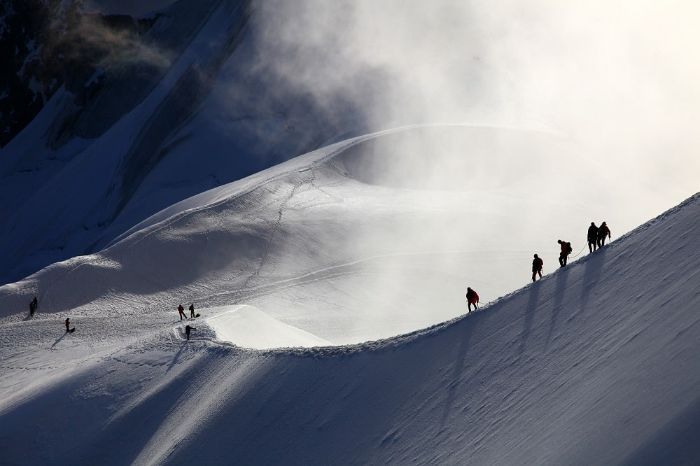Un groupe d'alpinistes en route pour le mont blanc à l'aube.