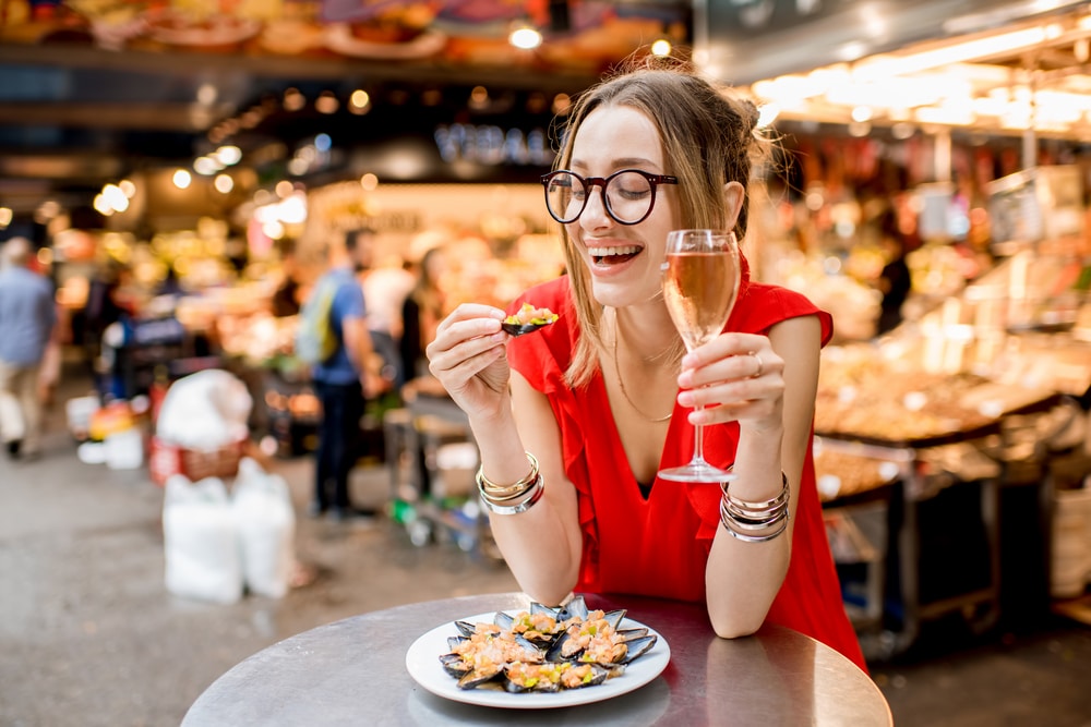 Femme qui mange des tapas dans un marché à Barcelone