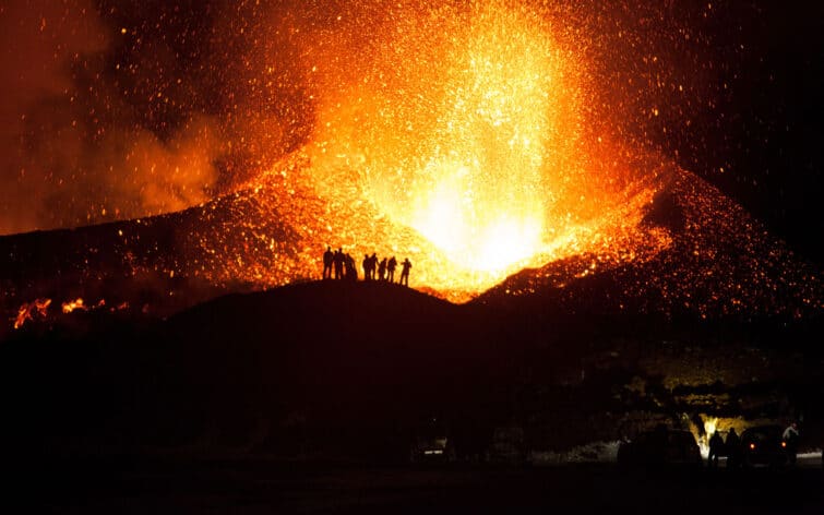 People watching the Eyjafjallajökull volcano erupt on Iceland.
