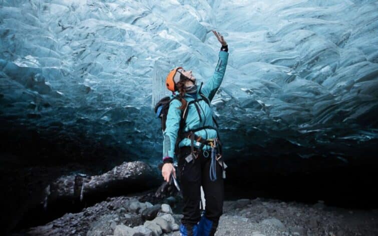 femme touchant glace bleue grotte de glace Islande