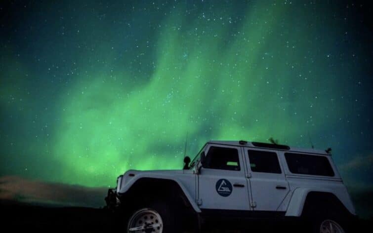 Jeep devant aurore boréale islande
