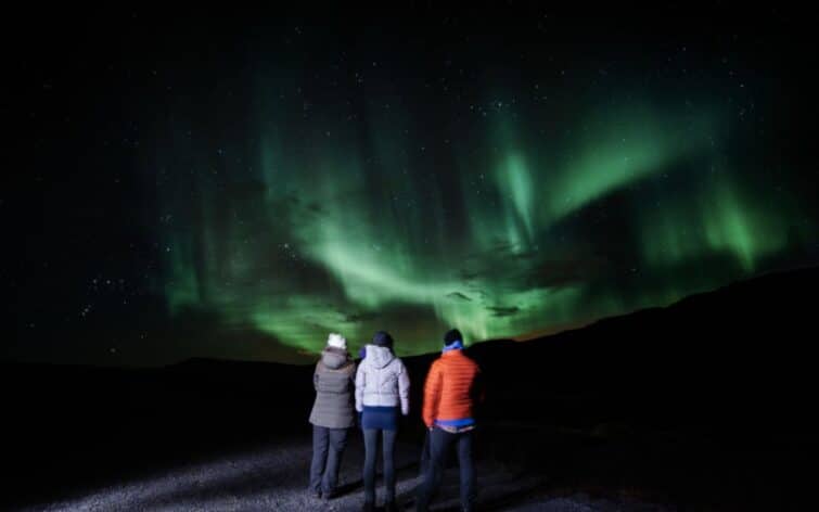 groupe de 3 personnes devant aurore boréale Islande
