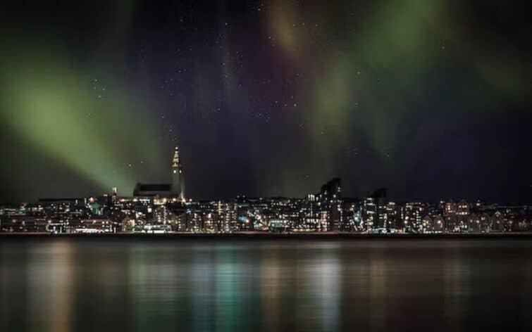aurore boréale sur Reykjavik depuis la mer
