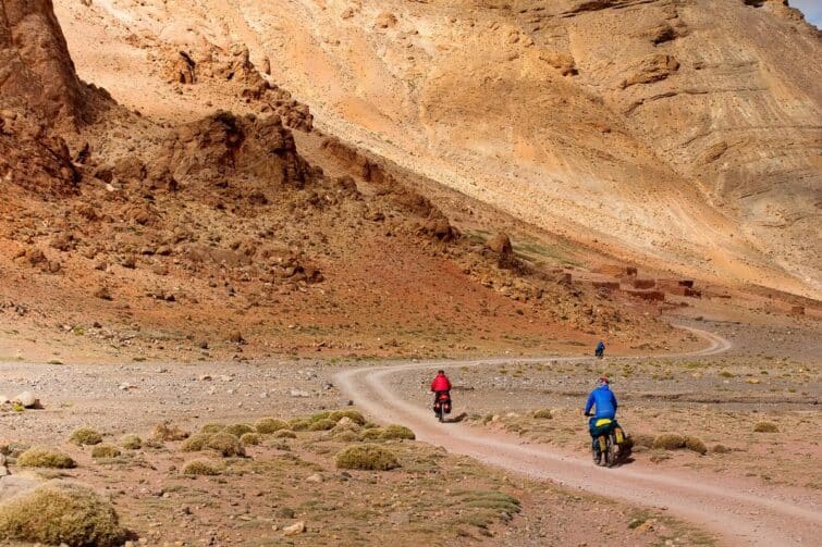 Deux cyclistes sur une route sinueuse du massif de l'Atlas, Maroc