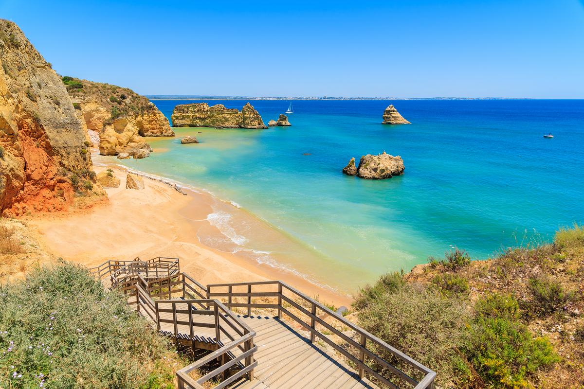 Promenade en bois jusqu'à Praia Dona Ana avec eau de mer turquoise et falaises, Lagos, Portugal