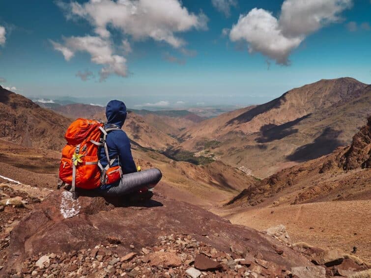 Une femme assise dans l'Atlas au Maroc avec son sac à dos