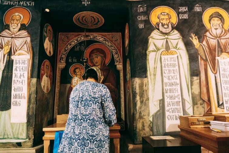 Fidèle devant les icônes du monastère d'Ostrog
