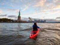 femme faisant du kayak près de la Statue de la Liberté