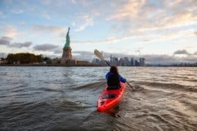 femme faisant du kayak près de la Statue de la Liberté