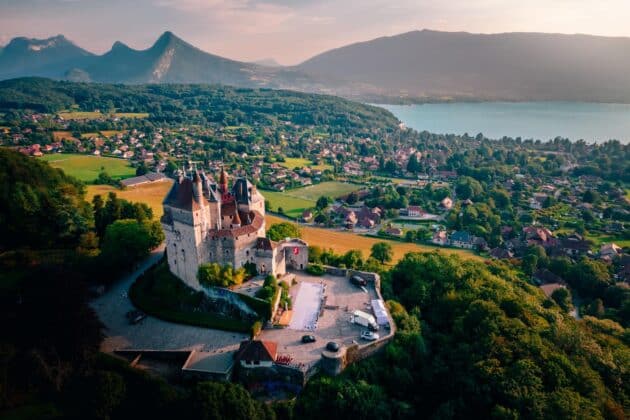 photo aérienne du Château de Menthon-Saint-Bernard surplombant la ville et le lac d'Annecy, France