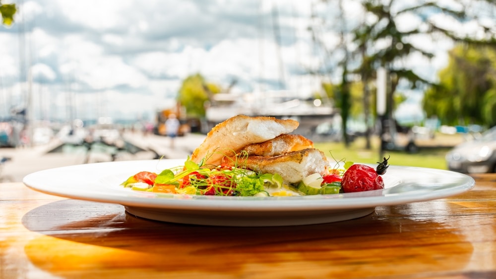 Des couches de poisson et de légumes sur une assiette au lac Balaton.