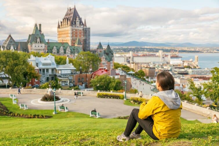 touriste au Québec avec vue sur le château Frontenac et le fleuve Saint-Laurent