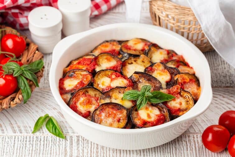 Parmigiana di melanzane, faite maison avec mozzarella, tomate et feuilles de basilic