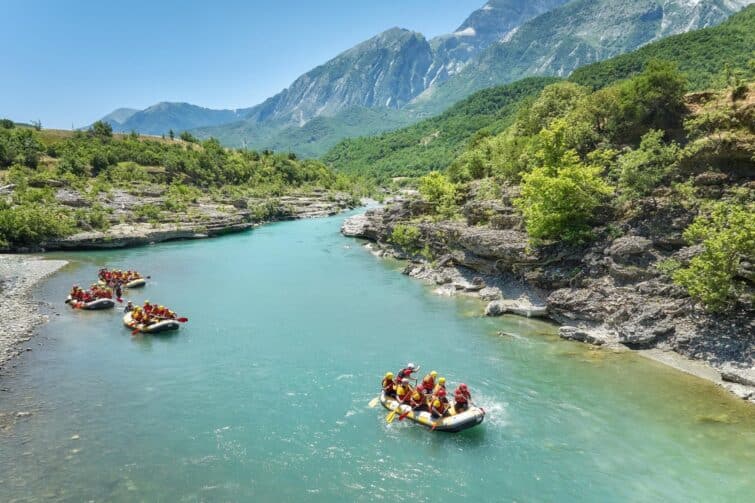 Un groupe de quatre radeaux de rafting sur l'eau cristalline de la rivière Vjosa, Albanie