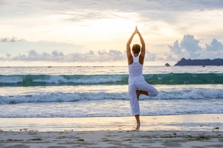 Yoga sur la plage face à l'océan