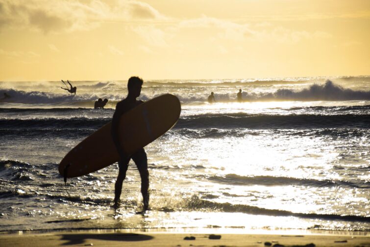 Des surfeurs au coucher du soleil à Saint-Leu à la Réunion