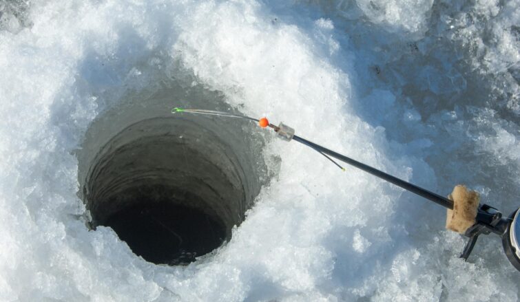 Un trou pour la pêche sur glace dans la rivière Torne, Kiruna, Suède