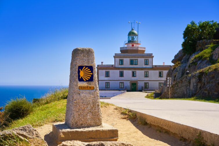 Le panneau de fin du chemin de Saint-Jacques-de-Compostelle et le phare de Finisterre en Galice, Espagne