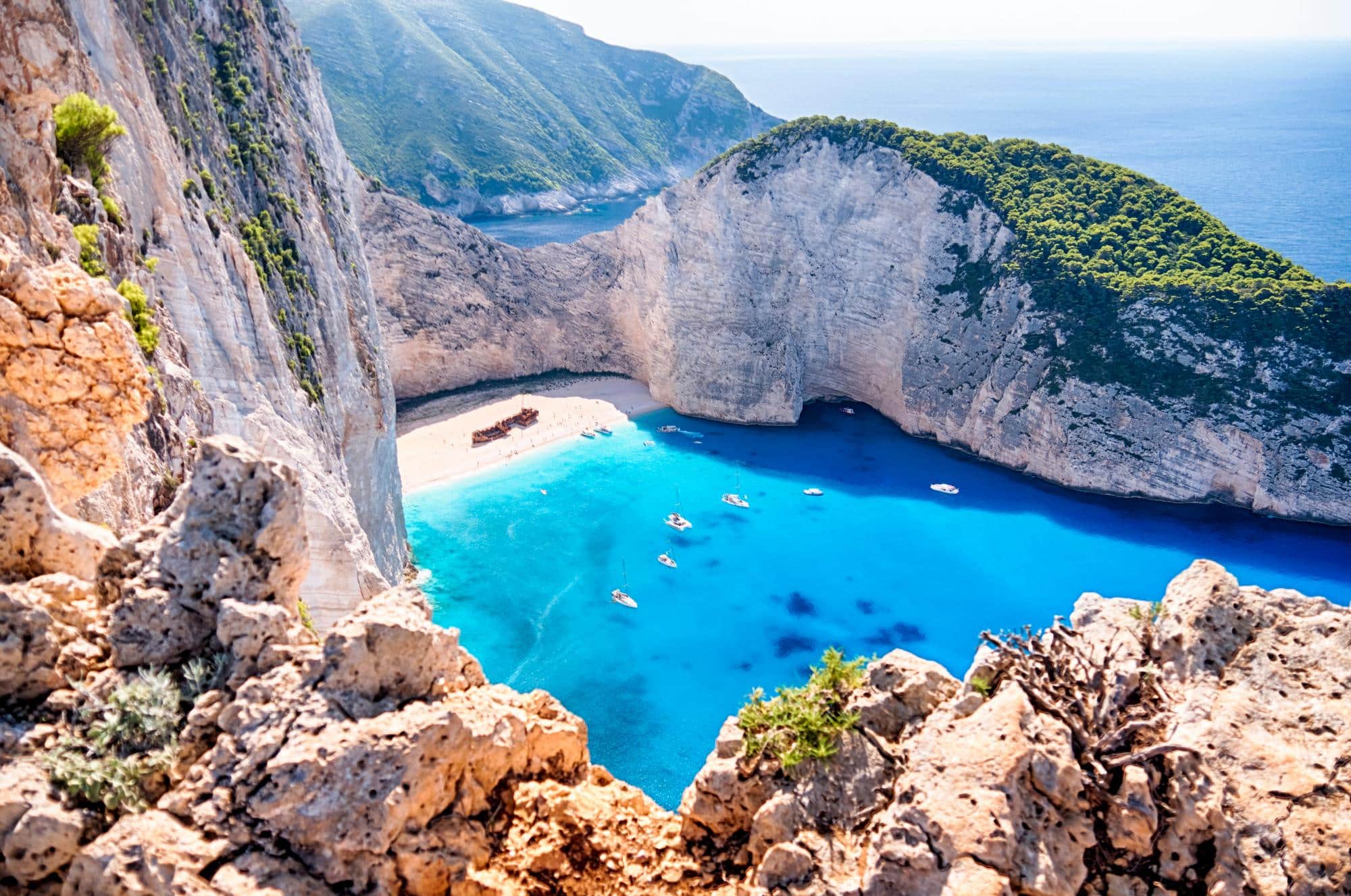 Plage de Navagio en Grèce avec son célèbre navire échoué sur le sable entouré d'eaux turquoise et de falaises blanches