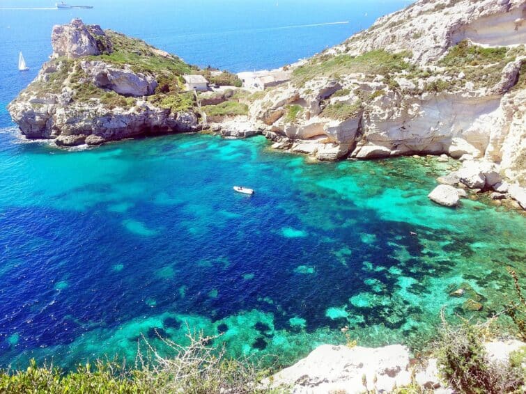 Cove Cala Fighera in Sardinia, Italy with clear turquoise water surrounded by rocky cliffs, perfect for a boat tour in the Gulf of Cagliari.