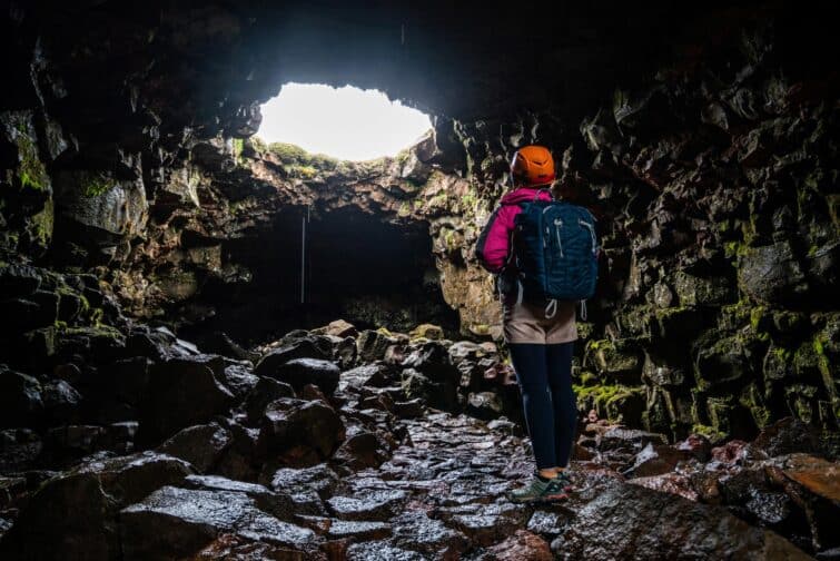 Femme explorant le tunnel de lave Raufarhólshellir en Islande