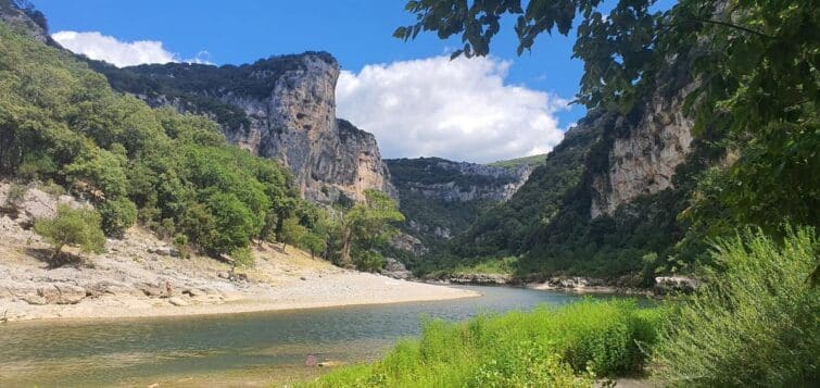 Randonnée dans les gorges de l'Ardèche avec un sentier et des falaises calcaires en arrière-plan