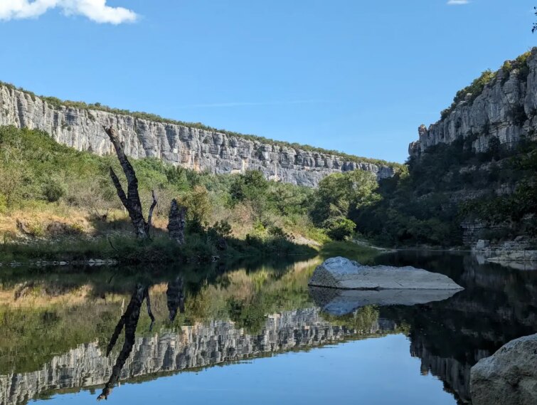 Randonneurs sur le sentier du cirque des Gens en Ardèche, paysage de falaises et de rivière