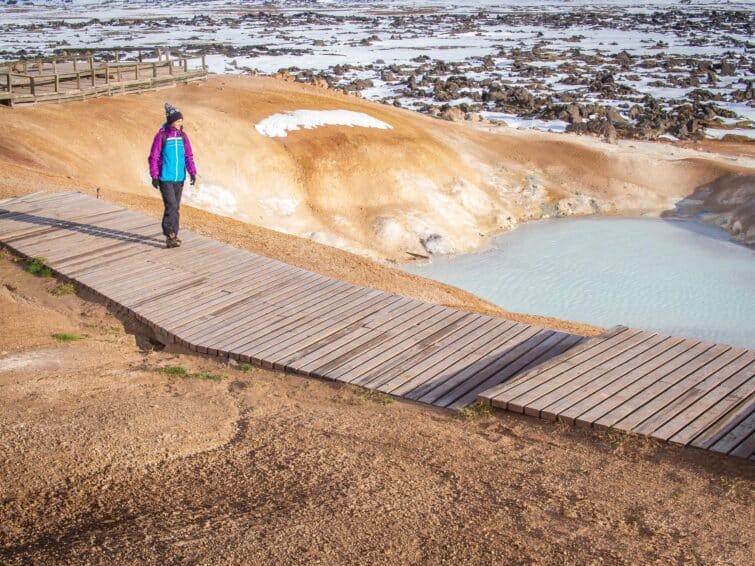 Touriste marchant près des sources de soufre au champ de lave de Leirhnjúkur en Islande