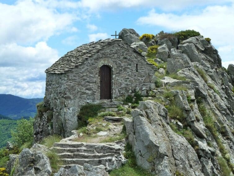 Vue panoramique de la chapelle de Soutron en Ardèche, entourée de verdure et de montagnes