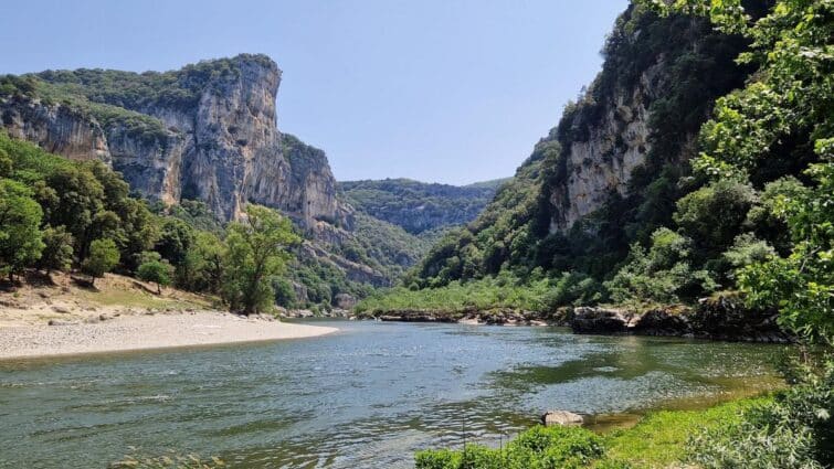 Vue panoramique des Gorges de l'Ardèche en France, montrant des falaises abruptes et la rivière Ardèche serpentant à travers la vallée