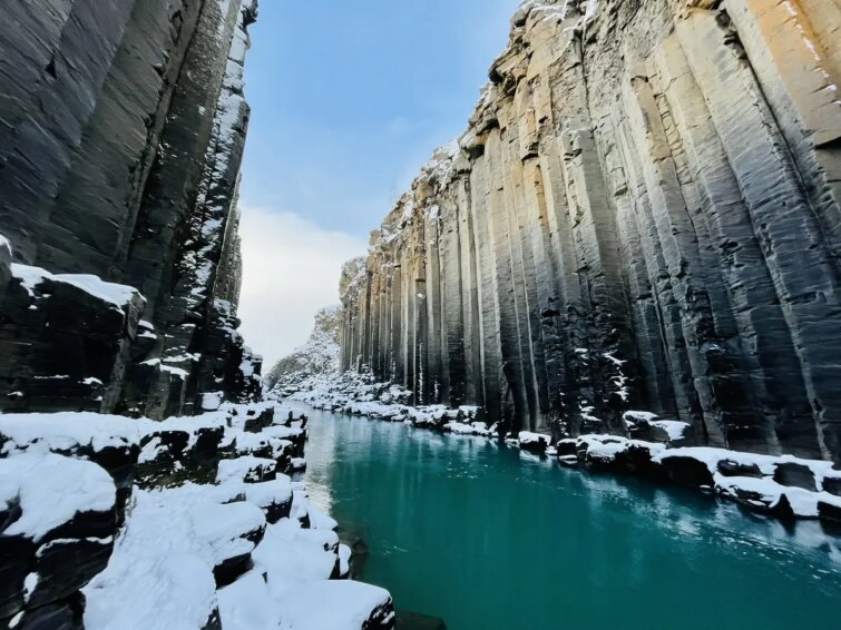 Vue panoramique du canyon Stuðlagil avec ses formations basaltiques et la rivière bleue ci-dessous