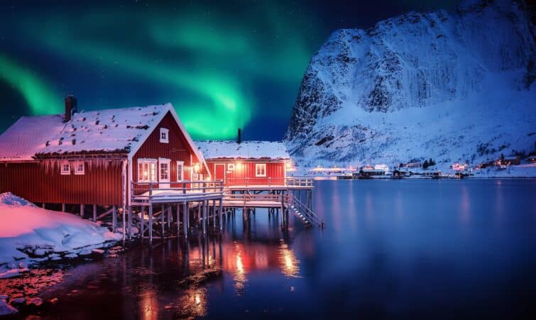 Aurores boréales illuminant le ciel au-dessus d'un village de pêcheurs en hiver aux îles Lofoten, Norvège