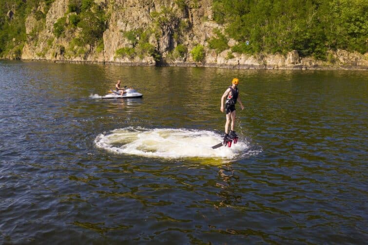 Homme effectuant du flyboard au-dessus de l'eau avec un casque à Orlik nad Vltavou, République tchèque