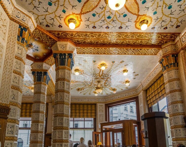 Intérieur du Café Impérial à Prague décoré de mosaïques et rempli de visiteurs