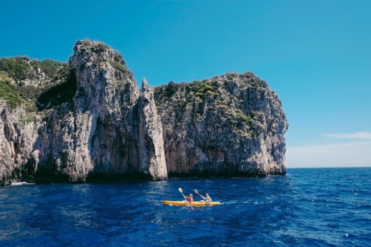 Kayak dans la baie de Naples avec vue sur les Faraglioni de l'île de Capri, Campanie, Italie