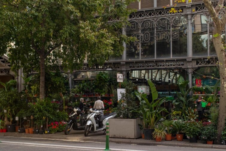 Marché de la Concepción à Barcelone, Espagne, avec des étals colorés et des clients en train de faire leurs achats