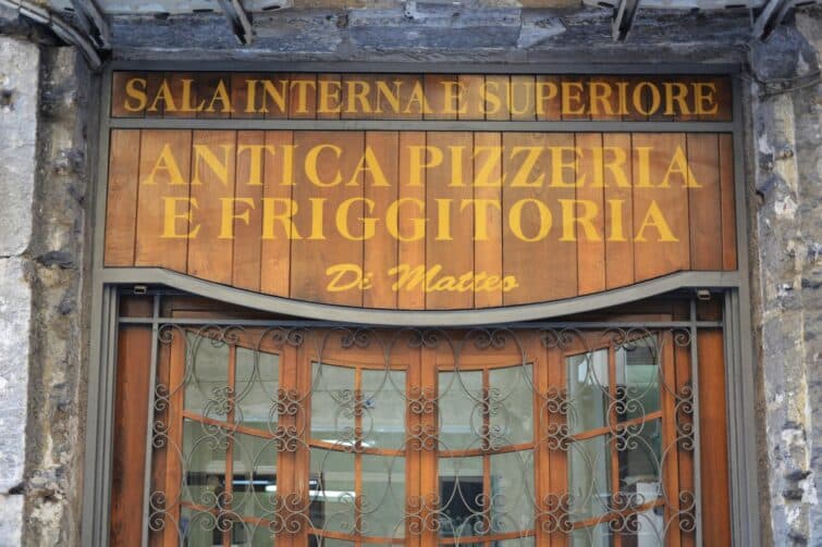 Personnes attablées à la Pizzeria Di Matteo à Naples, Italie, appréciant une authentique cuisine locale