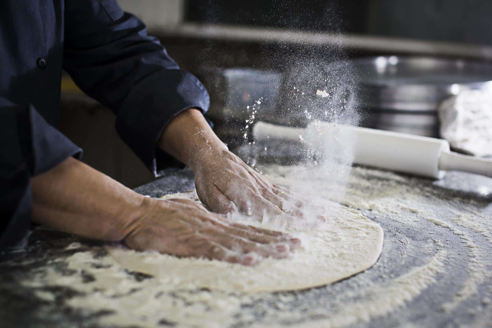 Pizzaiolo à Naples préparant une pizza avec de la farine et des pâtes