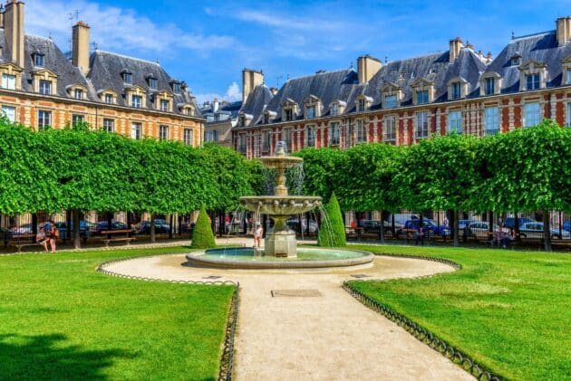 Place des Vosges à Paris, vue sur des bâtiments historiques et des visiteurs flânant